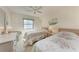 Comfortable bedroom with two twin beds, ceiling fan, and natural light from the large window at 630 Bird Bay E Dr # 208, Venice, FL 34285