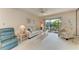 Bright living room with comfortable furnishings, ceiling fan, and sliding glass doors to a private balcony at 630 Bird Bay E Dr # 208, Venice, FL 34285