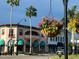 Charming buildings with awnings and hanging flower baskets line a street with tropical palm trees at 630 Bird Bay E Dr # 208, Venice, FL 34285