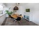 Bright dining area features gray laminate floors, a plant, and a white accent cabinet at 638 Bird Bay E Dr # 201, Venice, FL 34285