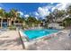 The community pool area features lounge seating and mature trees, with building in the background at 638 Bird Bay E Dr # 201, Venice, FL 34285