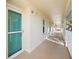 Exterior hallway features a bright, light-blue entry door with security screen and plenty of natural light at 7294 Cloister Dr # 27, Sarasota, FL 34231