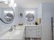 Bathroom featuring double sinks with granite countertops, and decorative mirrors and light fixtures at 8 Bunker Ln, Rotonda West, FL 33947