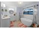 Bathroom featuring a soaking tub under window, quartz countertop, and modern fixtures and decor at 8 Bunker Ln, Rotonda West, FL 33947