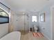 Beautiful bathroom featuring a modern glass-walled shower, soaking tub, toilet and decorative window at 8 Bunker Ln, Rotonda West, FL 33947