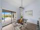 Chic dining room featuring wood floors, contemporary lighting, and sliding glass doors leading to the outdoor patio at 8 Bunker Ln, Rotonda West, FL 33947