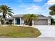 Charming home features lush landscaping, freshly painted exterior, and a two-car garage at 8 Bunker Ln, Rotonda West, FL 33947