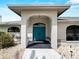Inviting entryway showcasing a modern arched entrance with a vibrant door and meticulously landscaped surroundings at 8 Bunker Ln, Rotonda West, FL 33947
