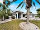 Charming single-story home featuring a well-manicured lawn, blue door, and tasteful landscaping with palm trees at 8 Bunker Ln, Rotonda West, FL 33947