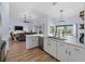 Open-concept kitchen flows into dining and living areas, boasting white cabinets, quartz countertops, and modern appliances at 8 Bunker Ln, Rotonda West, FL 33947