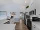 Modern kitchen with white cabinets, stainless steel appliances, open shelving and sleek countertops providing ample workspace at 8 Bunker Ln, Rotonda West, FL 33947
