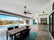 Outdoor dining area overlooking a pool and backyard, featuring a ceiling fan and grilling area for outdoor entertaining at 8 Bunker Ln, Rotonda West, FL 33947
