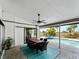 Inviting covered patio with ceiling fan and outdoor dining overlooking the sparkling swimming pool and fenced yard at 8 Bunker Ln, Rotonda West, FL 33947
