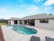 Backyard oasis featuring a sparkling pool and integrated spa surrounded by an expansive patio and lush landscaping at 8 Bunker Ln, Rotonda West, FL 33947