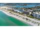 Breathtaking aerial view of a coastal community with beachfront condos, a marina, and turquoise waters at 840 The Esplanade N # 301, Venice, FL 34285