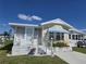 Cozy single-Gathering home with a screened porch and a blue striped awning at 88 Bainbridge Dr # 88, Nokomis, FL 34275