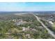 Aerial view shows the boundaries of a property with a pond and rural structures amongst dense trees and foliage at 964 1St Dirt Rd, Venice, FL 34292