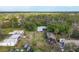 Aerial view displays multiple structures on property amidst lush trees and greenery, creating a peaceful and secluded setting at 964 1St Dirt Rd, Venice, FL 34292