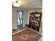 Cozy room featuring a vintage rug, open shelving, and bright natural light from the sheer-curtained doorway at 964 1St Dirt Rd, Venice, FL 34292
