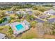 Aerial view of community pool with lounge chairs, pond, and mature trees at 1051 Forrest Nelson Blvd # A-103, Port Charlotte, FL 33952