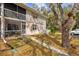 Townhouse exterior with a screened-in porch, mature trees, and lush landscaping at 1051 Forrest Nelson Blvd # A-103, Port Charlotte, FL 33952
