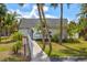 Charming pool area with a gated entrance, lounge chairs, and tropical landscaping at 1051 Forrest Nelson Blvd # A-103, Port Charlotte, FL 33952