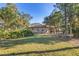 Expansive backyard featuring well-maintained lawn, mature trees and landscaping, providing privacy for the screened lanai and swimming pool at 1115 Gladstone Blvd, Englewood, FL 34223