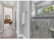 Bright bathroom featuring a walk-in shower with gray stone walls and pebble floor plus a view to the primary bedroom at 1115 Gladstone Blvd, Englewood, FL 34223