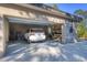 Two car garage with a white SUV, overhead shelving, tools, and two bicycles at 1115 Gladstone Blvd, Englewood, FL 34223