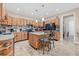 A large kitchen features an island with seating, tile backsplash, and wood cabinetry at 1115 Gladstone Blvd, Englewood, FL 34223