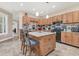 An island with seating complements the spacious kitchen with tile backsplash, and wooden cabinets at 1115 Gladstone Blvd, Englewood, FL 34223