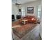 Living area with wood plank floors, orange sofa, and two windows with wood shutters at 1115 Gladstone Blvd, Englewood, FL 34223