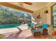 Inviting screened patio with comfortable seating overlooks the sparkling pool and lush landscaping at 1115 Gladstone Blvd, Englewood, FL 34223