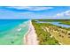 Breathtaking aerial view of the coastline featuring pristine beaches, lush mangroves, and clear turquoise waters at 13240 Amerigo Ln, Venice, FL 34293