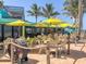 The outdoor seating at this beach restaurant is shaded by yellow umbrellas and lush palm trees at 1346 Capri Isles Blvd # 12, Venice, FL 34292