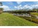 Scenic backyard view with grassy lawn, trees, and a tranquil lake at 142 Bella Vista Ter # A, North Venice, FL 34275