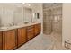 Bright bathroom featuring double sinks, wood cabinets, decorative rug and glass enclosed shower at 142 Bella Vista Ter # A, North Venice, FL 34275