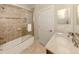 Well-lit bathroom with a marble countertop vanity and a tiled shower and tub with sliding glass door at 142 Bella Vista Ter # A, North Venice, FL 34275