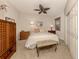 Bedroom with neutral walls, carpet, ceiling fan, wardrobe, and a bench at the end of the bed at 142 Bella Vista Ter # A, North Venice, FL 34275