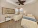 Cozy bedroom featuring two twin beds, carpeted floors, and a ceiling fan with decorative palm leaves at 142 Bella Vista Ter # A, North Venice, FL 34275