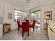 Bright breakfast nook with a glass table, red chairs, and natural light from surrounding windows at 142 Bella Vista Ter # A, North Venice, FL 34275