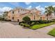 Beautiful Mediterranean-style home with a brick driveway and lush landscaping at 142 Bella Vista Ter # A, North Venice, FL 34275