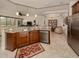 Open kitchen featuring granite countertops, stainless steel appliances, and an adjacent living area at 142 Bella Vista Ter # A, North Venice, FL 34275