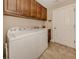 Functional laundry room with washer, dryer, ample cabinet space, and a utility sink at 142 Bella Vista Ter # A, North Venice, FL 34275