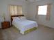 Bedroom features a comfortable bed, matching nightstand, and two bright windows with curtains at 157 Algiers Dr, Venice, FL 34293