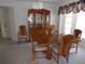 Traditional dining room with wooden table set, china cabinet, and bright natural lighting at 157 Algiers Dr, Venice, FL 34293