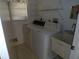 This laundry room features a washer, dryer, utility sink, and window for natural light at 157 Algiers Dr, Venice, FL 34293