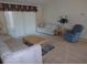 Cozy living room area with neutral carpeting, comfortable seating, and natural light at 157 Algiers Dr, Venice, FL 34293