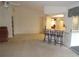 Open living area with a breakfast bar, view of kitchen and dining areas, and neutral carpet at 157 Algiers Dr, Venice, FL 34293