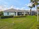 View of the home's backyard, showcasing lush landscaping, and a screened-in lanai at 1610 Monarch Dr # 1610, Venice, FL 34293
